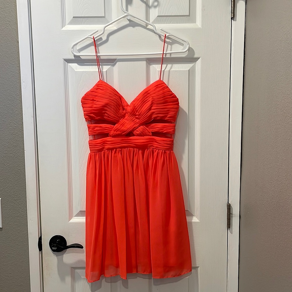 Bright coral dress with mesh cut outs, perfect for special occasion.